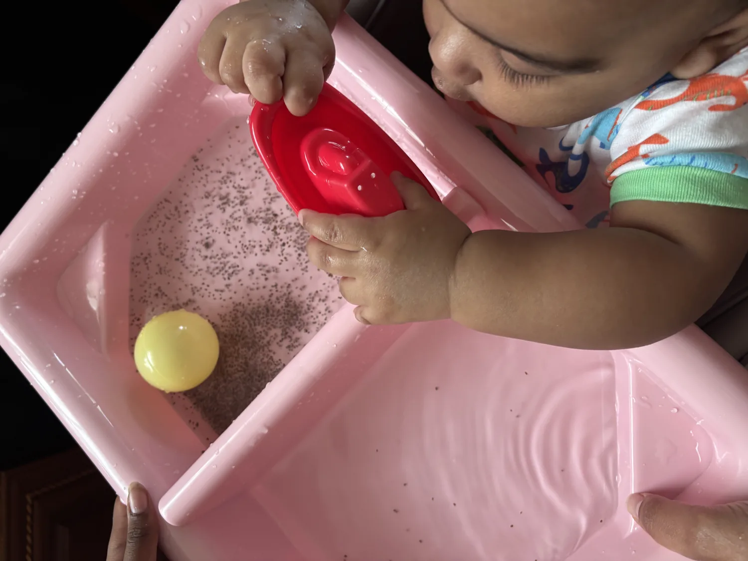 A baby exploring a supervised water-based sensory activity